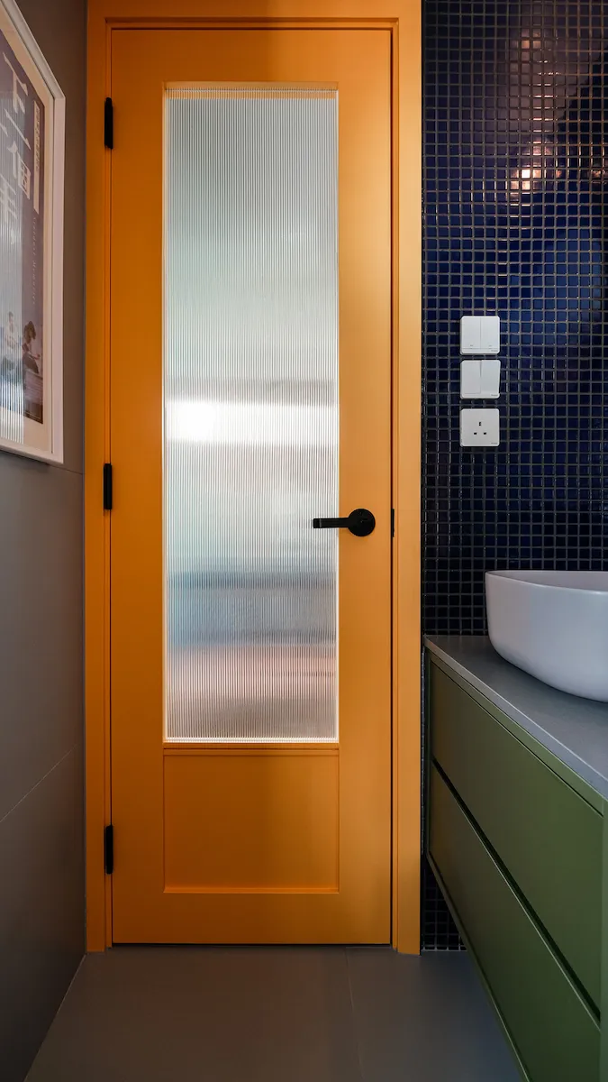 Patterned glass with blue mosaic tile and yellow door