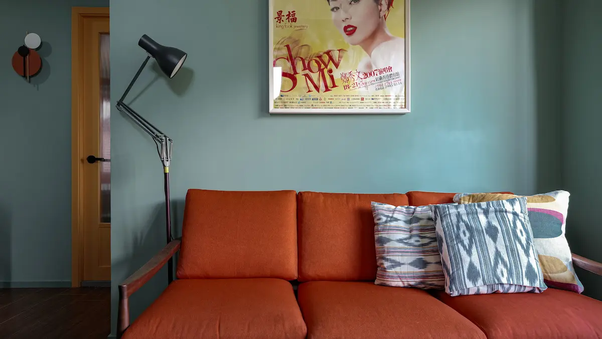 Living room with green wall, Sammi poster, and red sofa