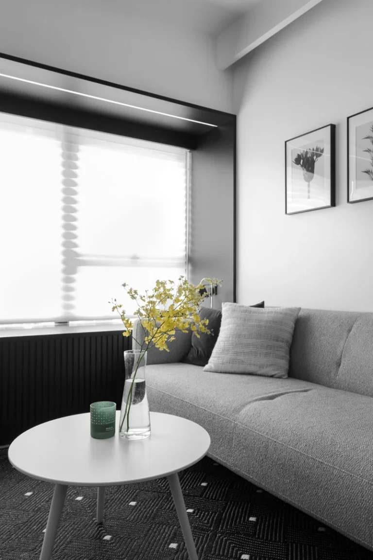 A black wood frame in the living room with a grey sofa